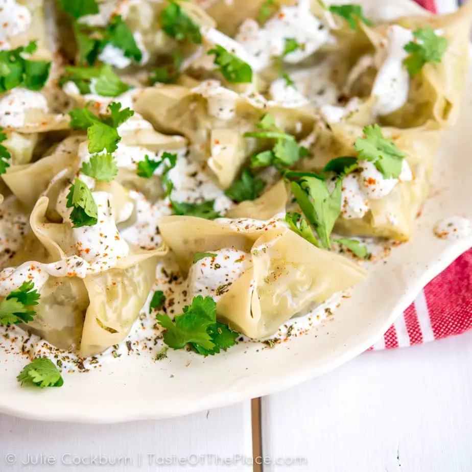 Seasoned beef and onions, tucked away in a tender wrapper, and topped with an herby yogurt sauce make this delicious recipe for Afghan mantu, or dumplings, a perfect crowd pleaser for your next party!